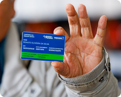 Mão de idoso segurando Carteira da Pessoa Idosa Paranaense